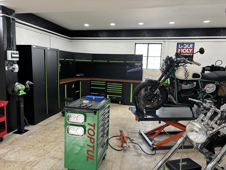 Royal Enfield motorcycle on the lift at Iron Custom Motors workshop in Cascais, Greater Lisbon