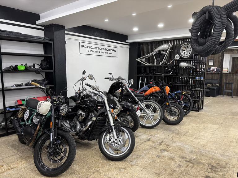 Suzuki motorcycle on the lift at Iron Custom Motors workshop in Cascais