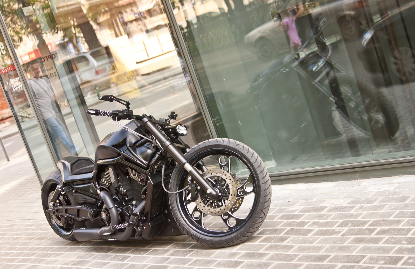 The First Night Rod custom front three-quarter view by a glass facade