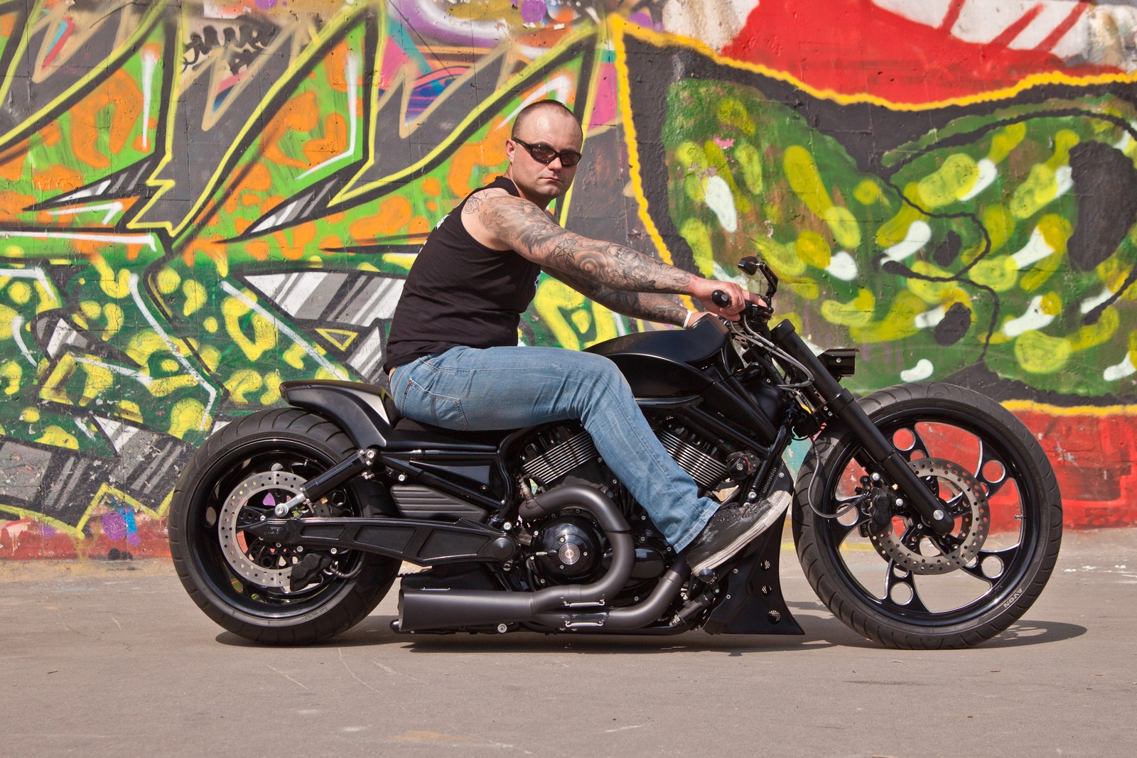The First Night Rod custom with its rider by a graffiti wall